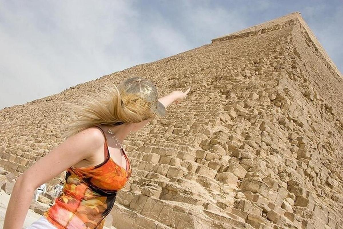 een vrouw die voor een bakstenen muur staat
