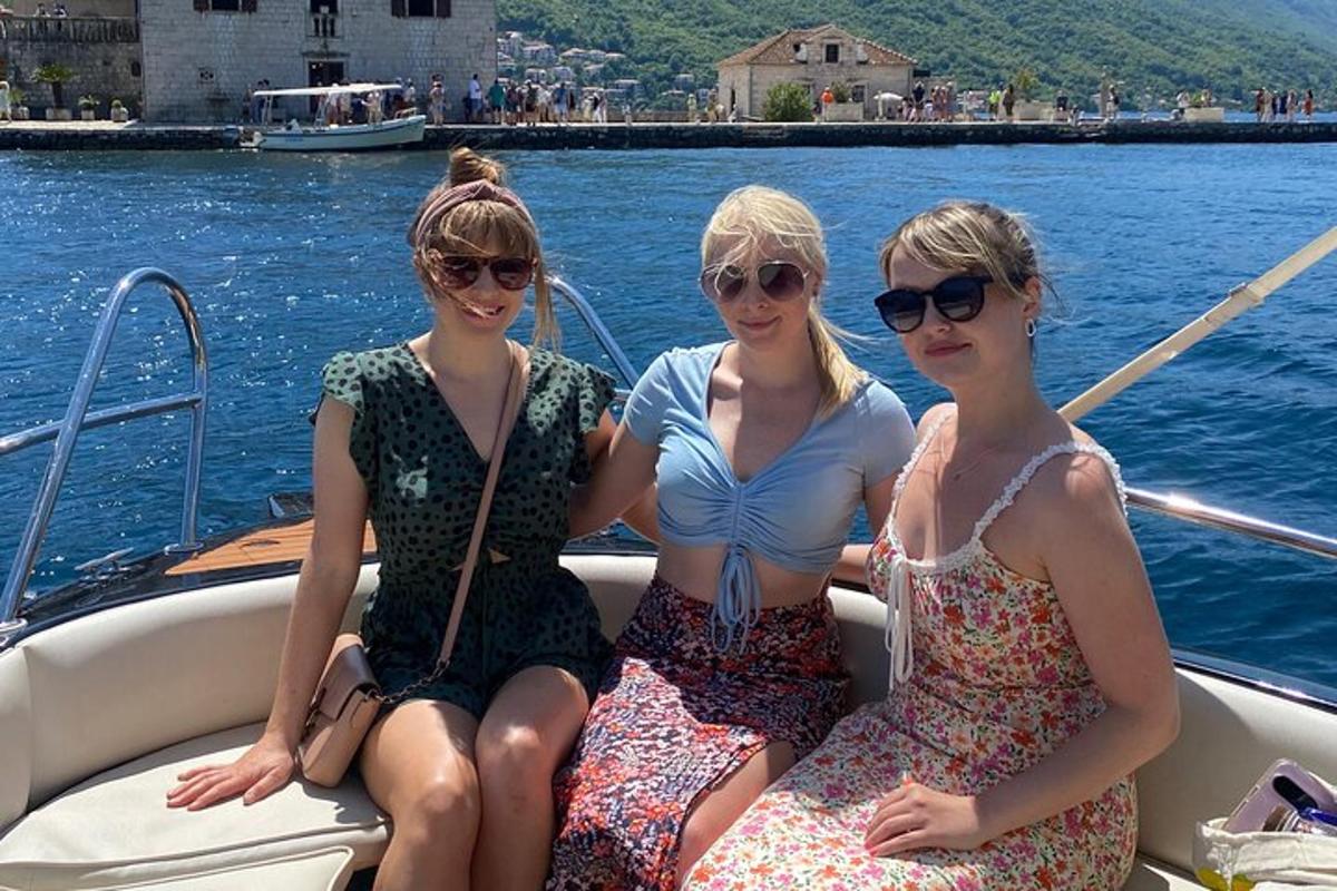 three women sitting in a boat on the water