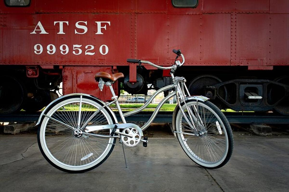 una bicicletta parcheggiata accanto a un treno rosso