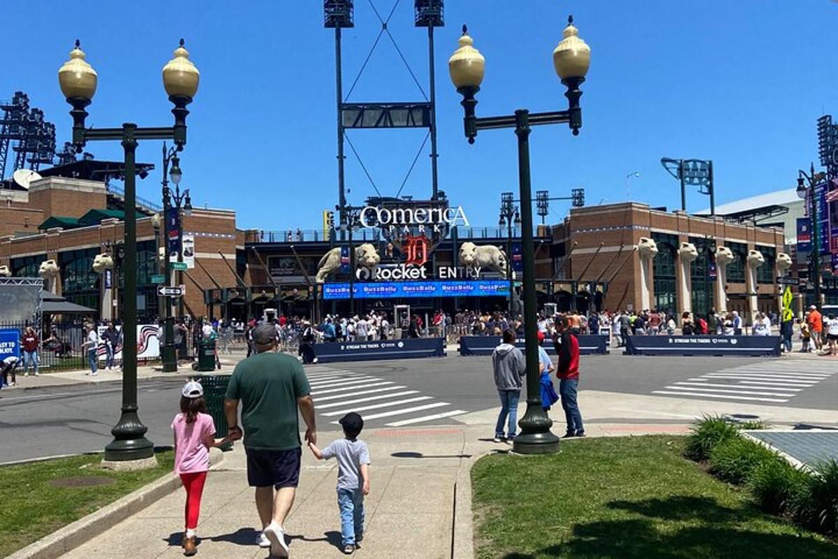 a group of people walking in front of a ballpark