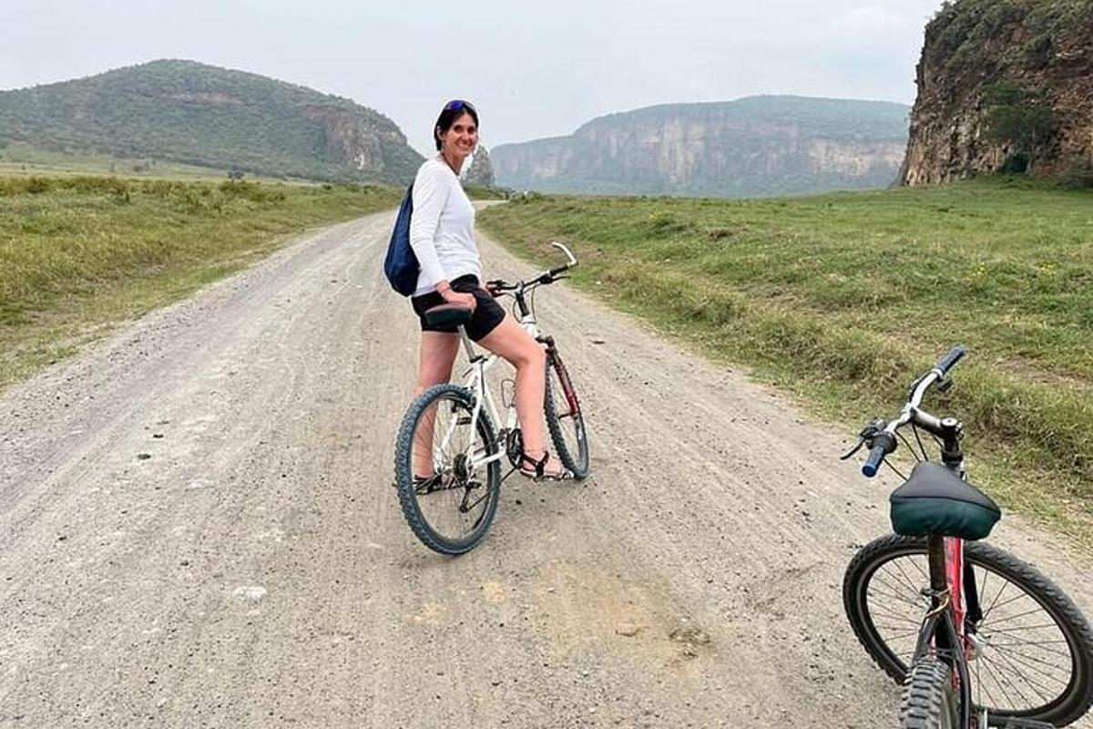 a woman riding a bike on a dirt road