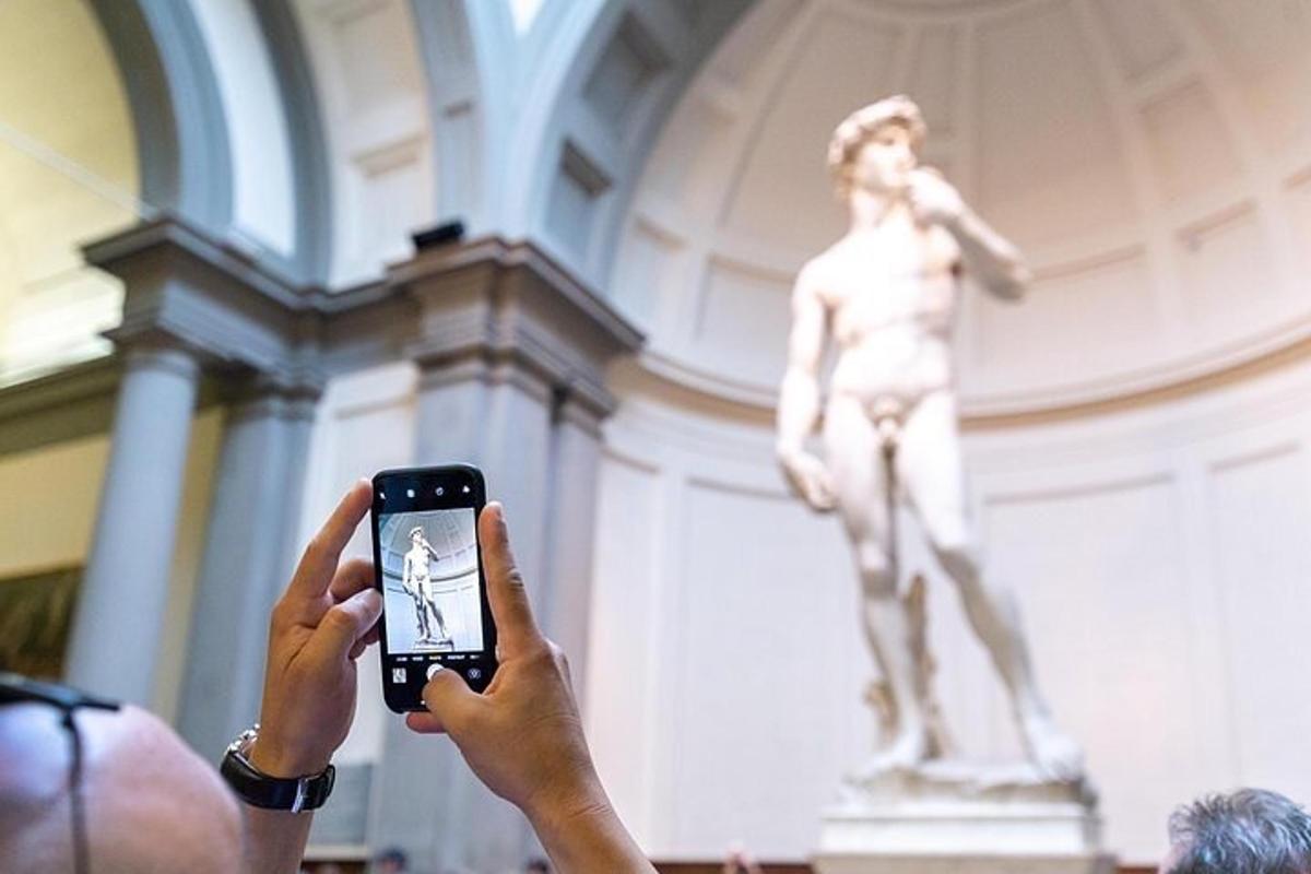 a man taking a picture of a statue with a cell phone