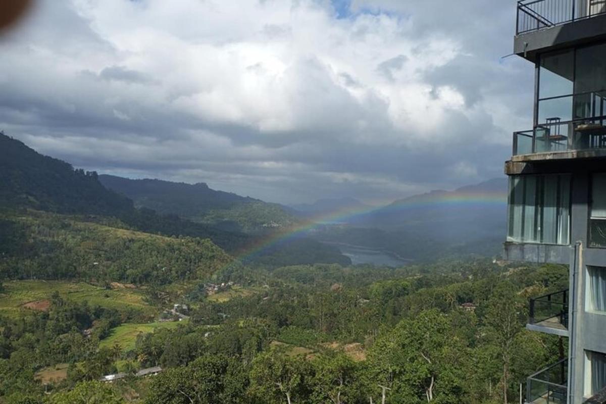 un arcobaleno sopra una valle con un edificio