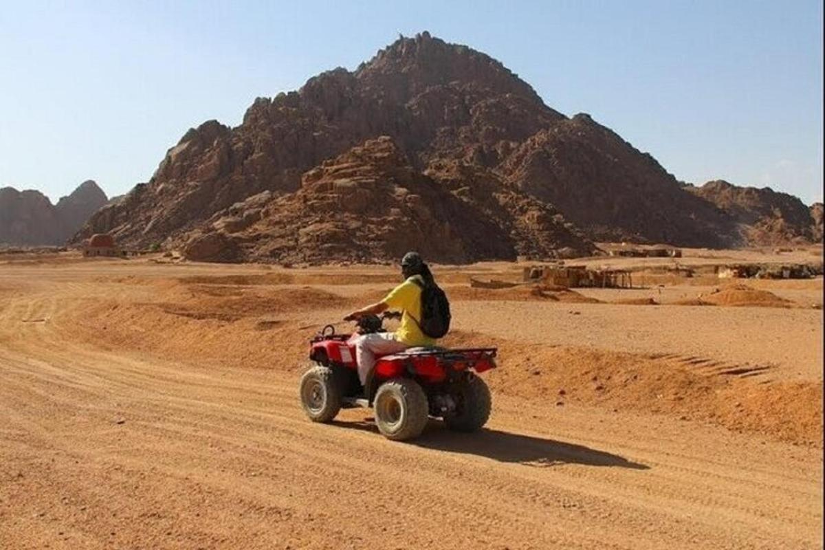 una persona conduciendo un quad en el desierto
