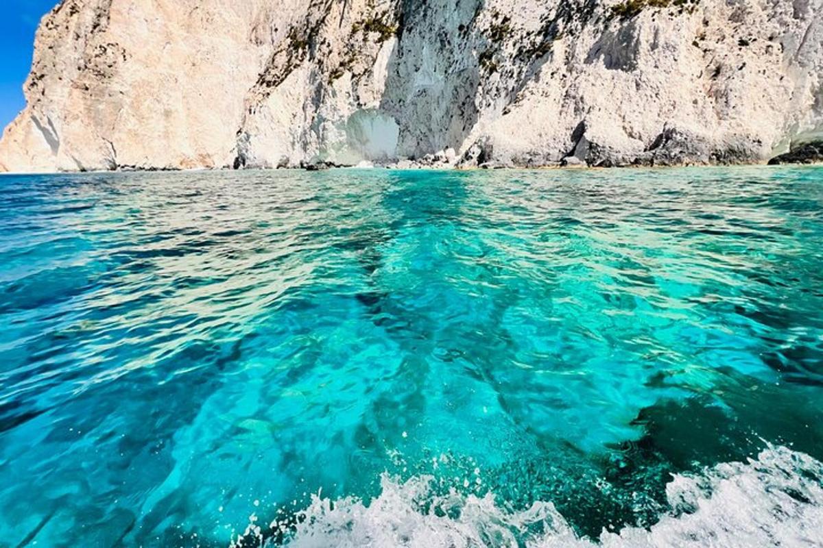 μια θέα του γαλάζιου νερού μπροστά από έναν απότομο βράχο