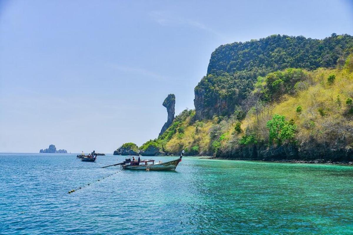 two boats in the water next to a mountain