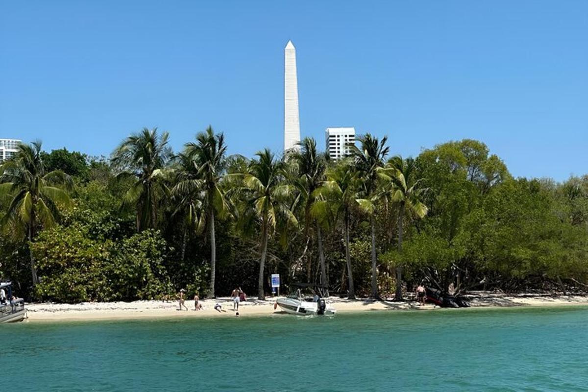 uma praia com palmeiras e uma torre ao fundo