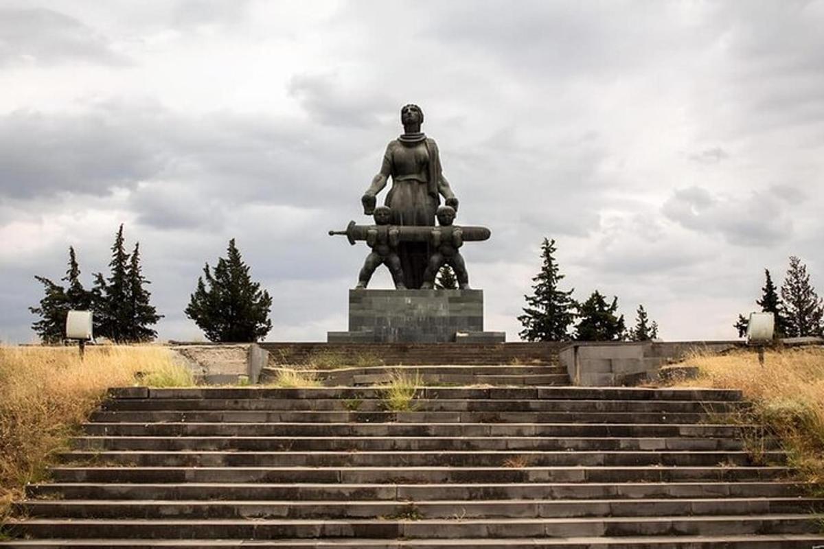 una statua di un uomo con una pistola davanti alle scale