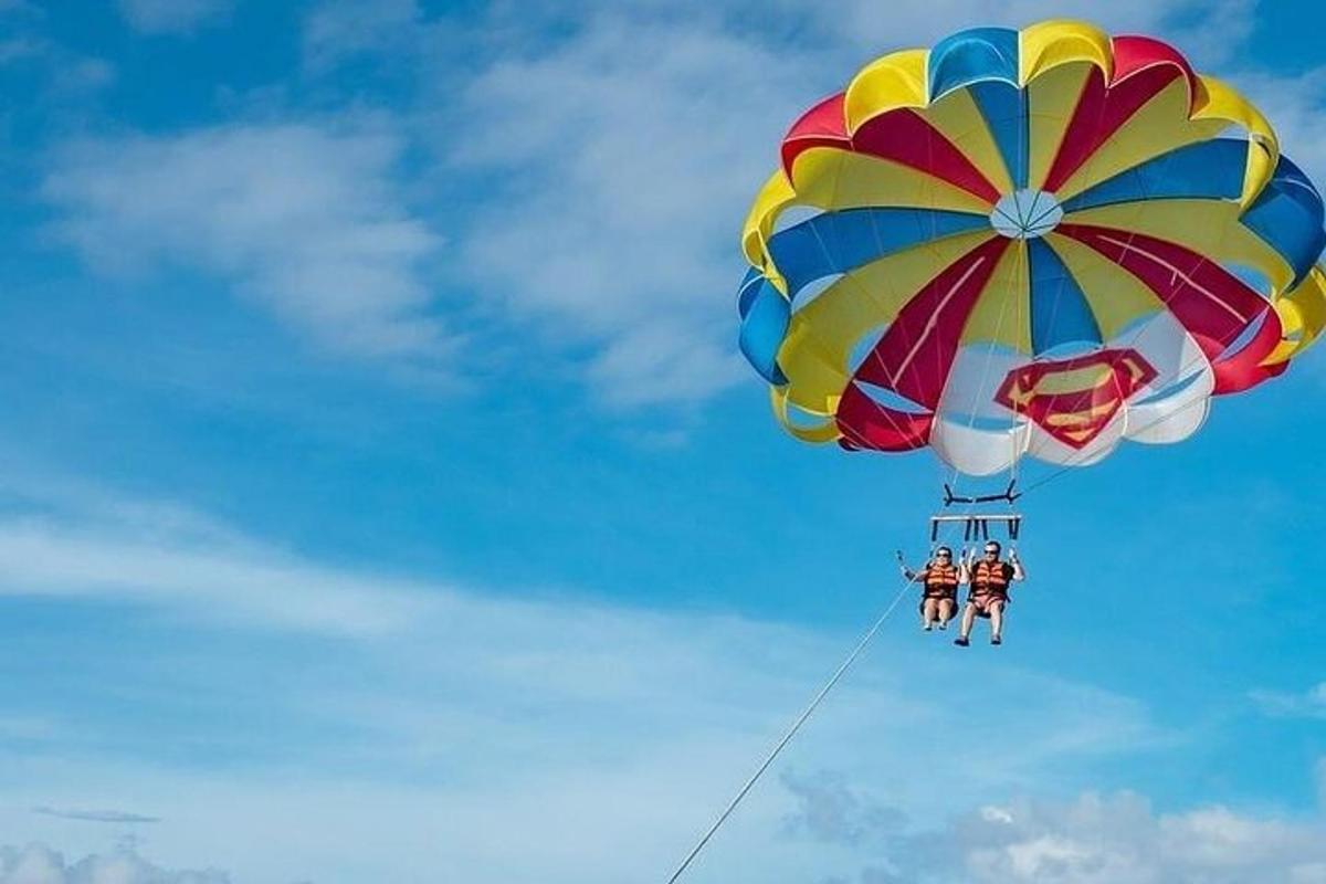 zwei Menschen auf einem bunten Fallschirm am Himmel