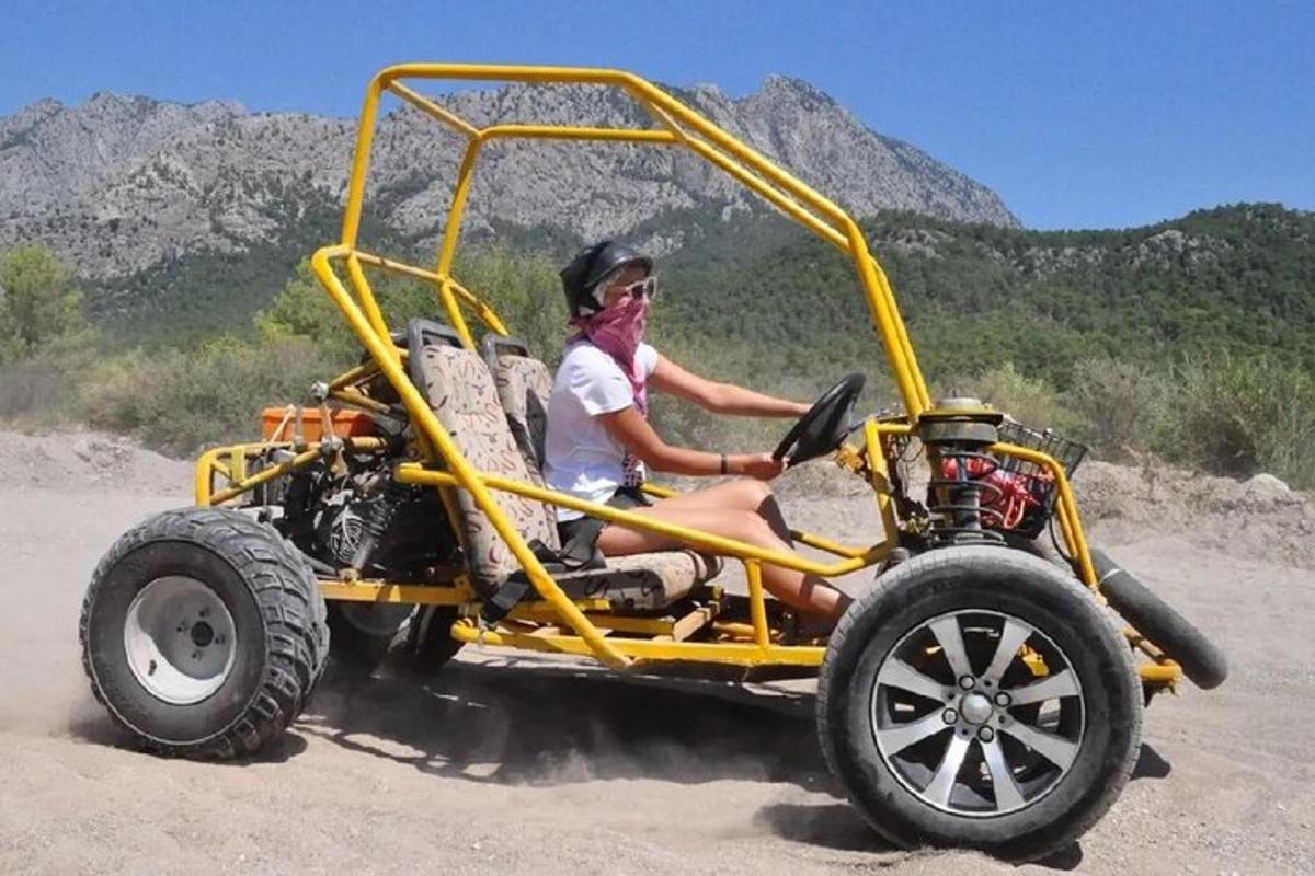 uma pessoa sentada em um quadriciclo amarelo na terra