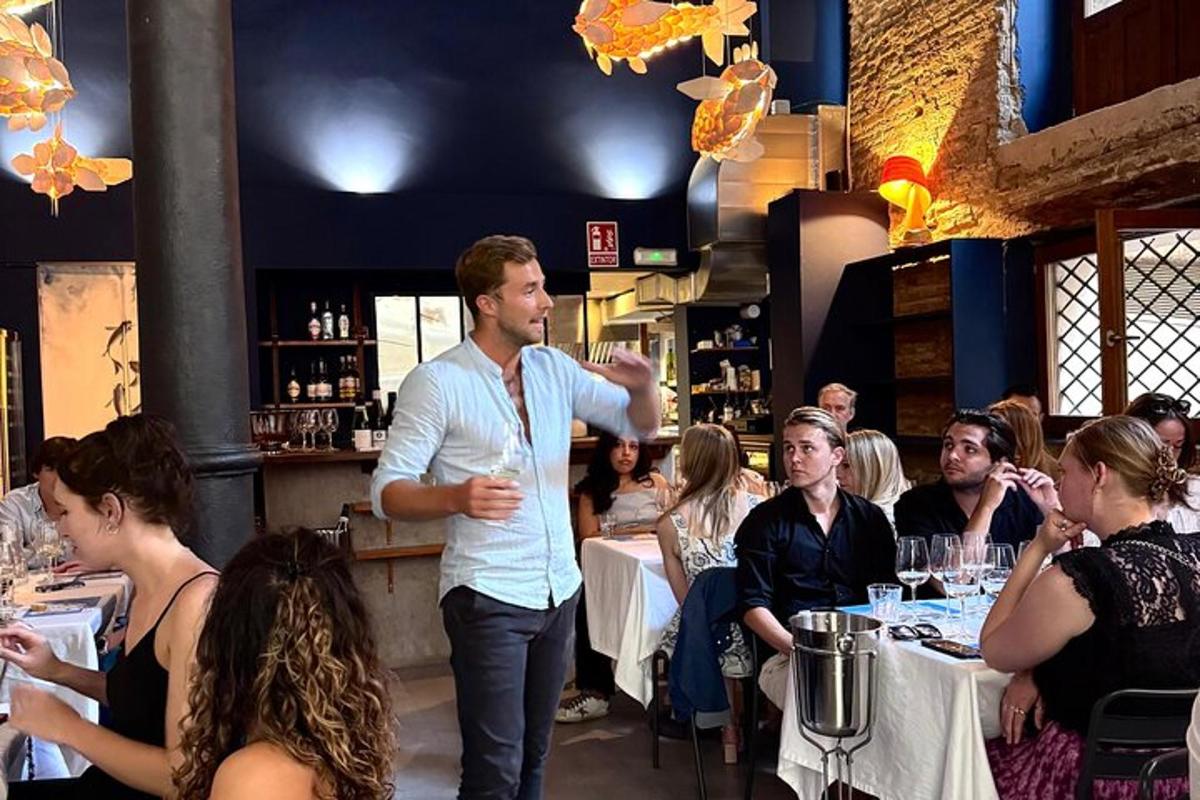 un uomo in piedi in un ristorante che parla con un gruppo di persone