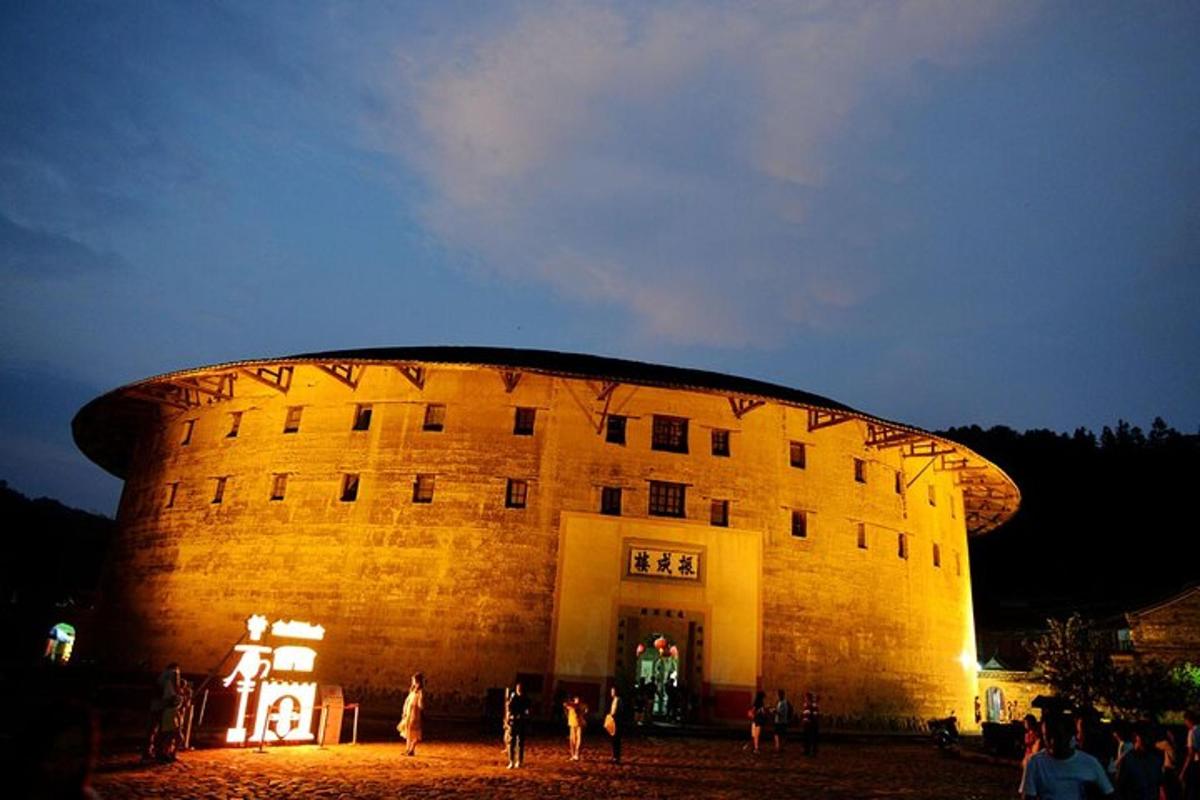 a large building with people standing outside of it at night