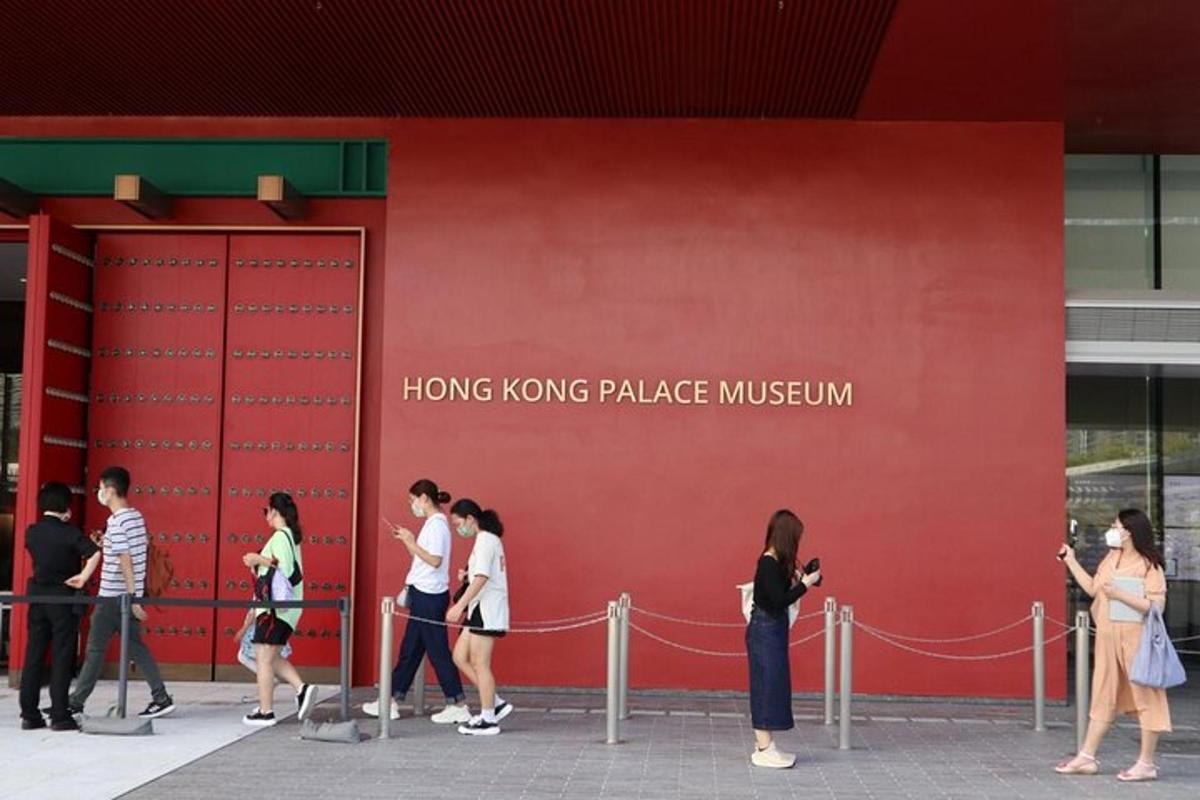 a group of people walking past a red building