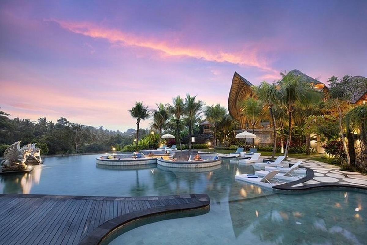 Una piscina en un resort con tumbonas blancas.
