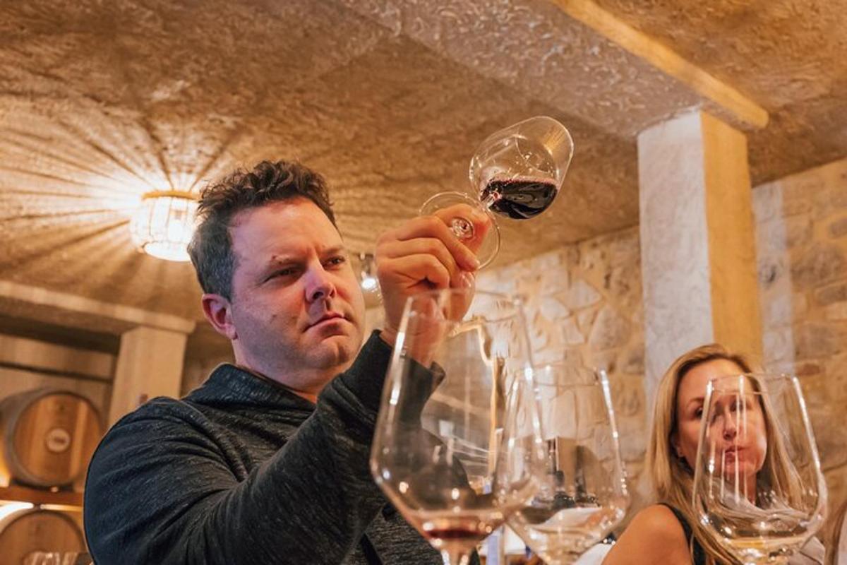moški drži kozarec vina