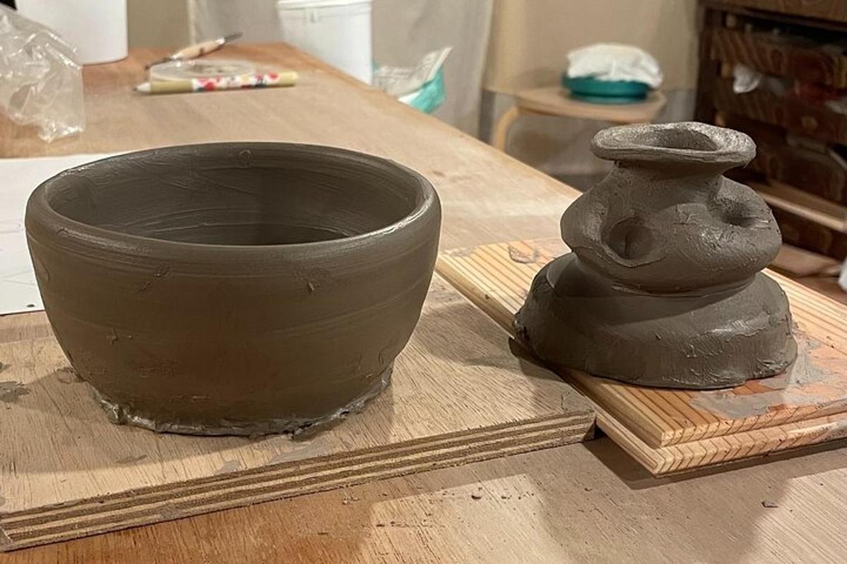 a clay vase sitting on a wooden table