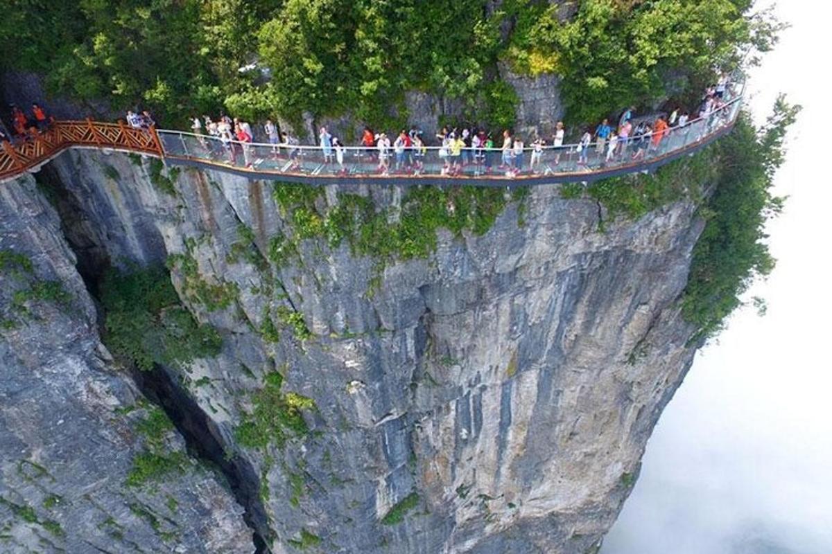 um grupo de pessoas em pé em uma ponte em uma montanha