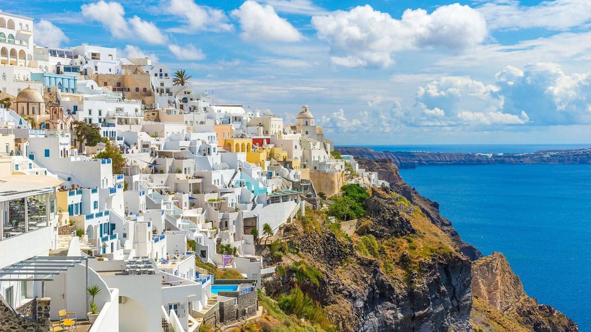 un gruppo di edifici bianchi su una collina vicino all'oceano