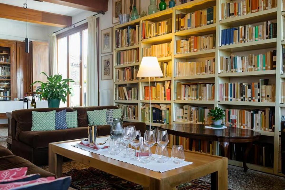 una biblioteca con un tavolo con bicchieri da vino sopra