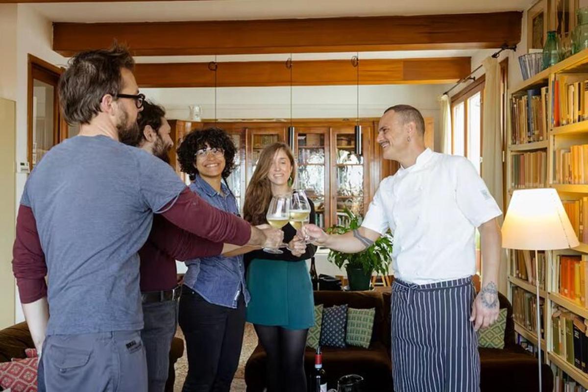 een groep mensen die in een woonkamer staan met glazen wijn in de hand