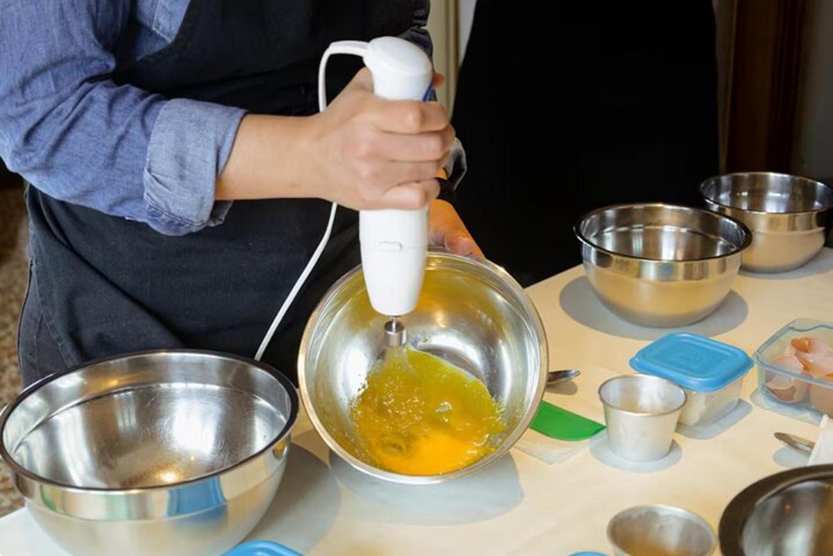 Una persona está mezclando huevos en un tazón sobre una mesa.