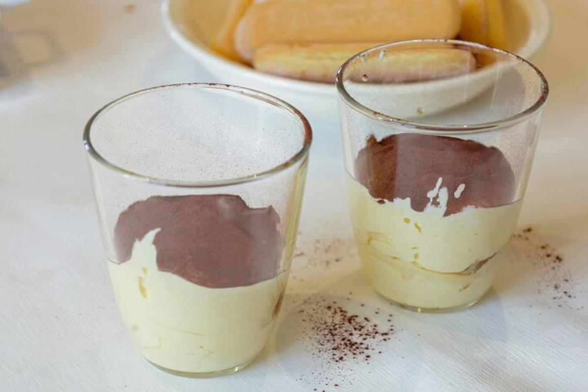 due bicchieri pieni di cioccolato e torta su un tavolo