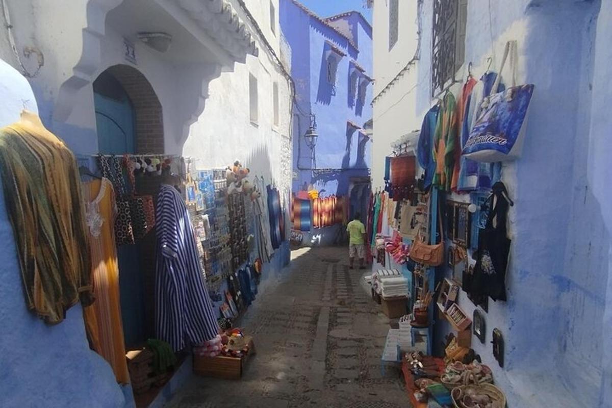 a narrow alley with a person walking down a street