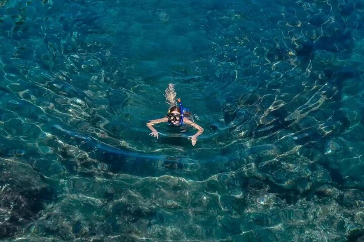 a person swimming in the clear blue water