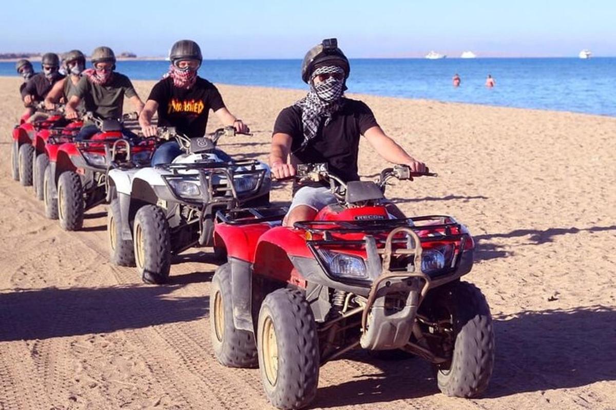 Un grupo de personas conduciendo vehículos todo terreno en la playa.