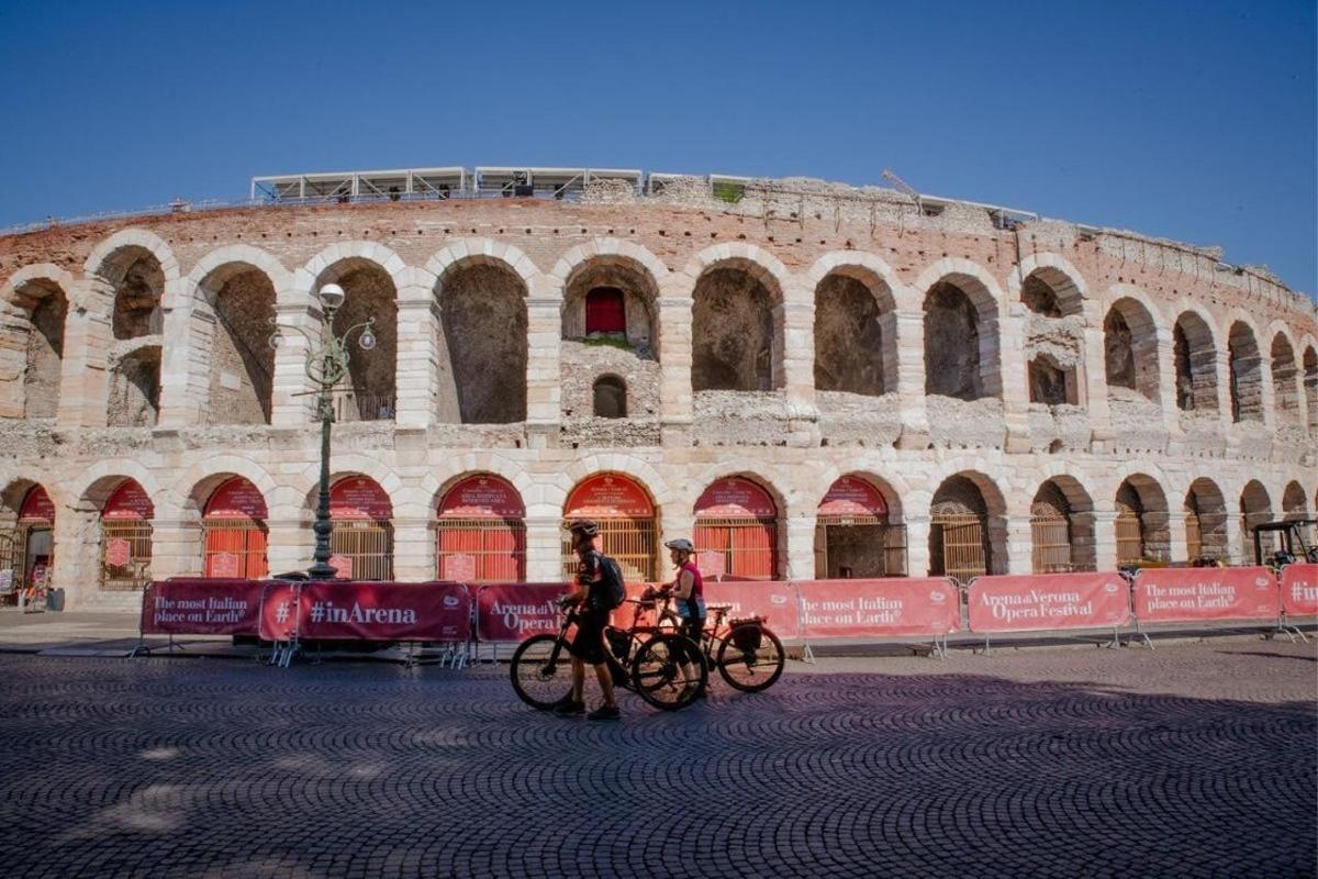two people riding bikes in front of a large building