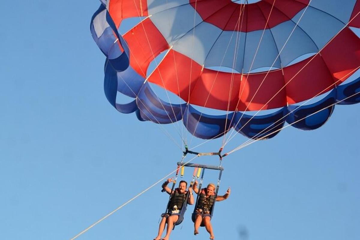three people are hanging from a parachute