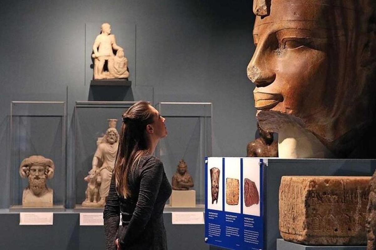 seorang wanita berdiri di hadapan pameran di sebuah muzium