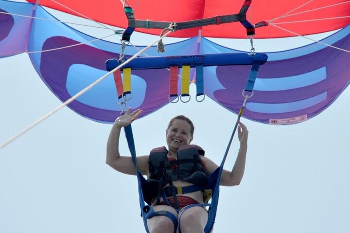 a girl in a life vest is riding on a parachute