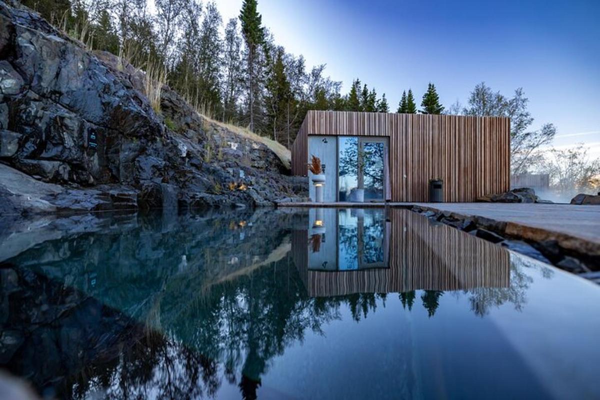 une petite maison en bois avec un reflet dans un plan d'eau