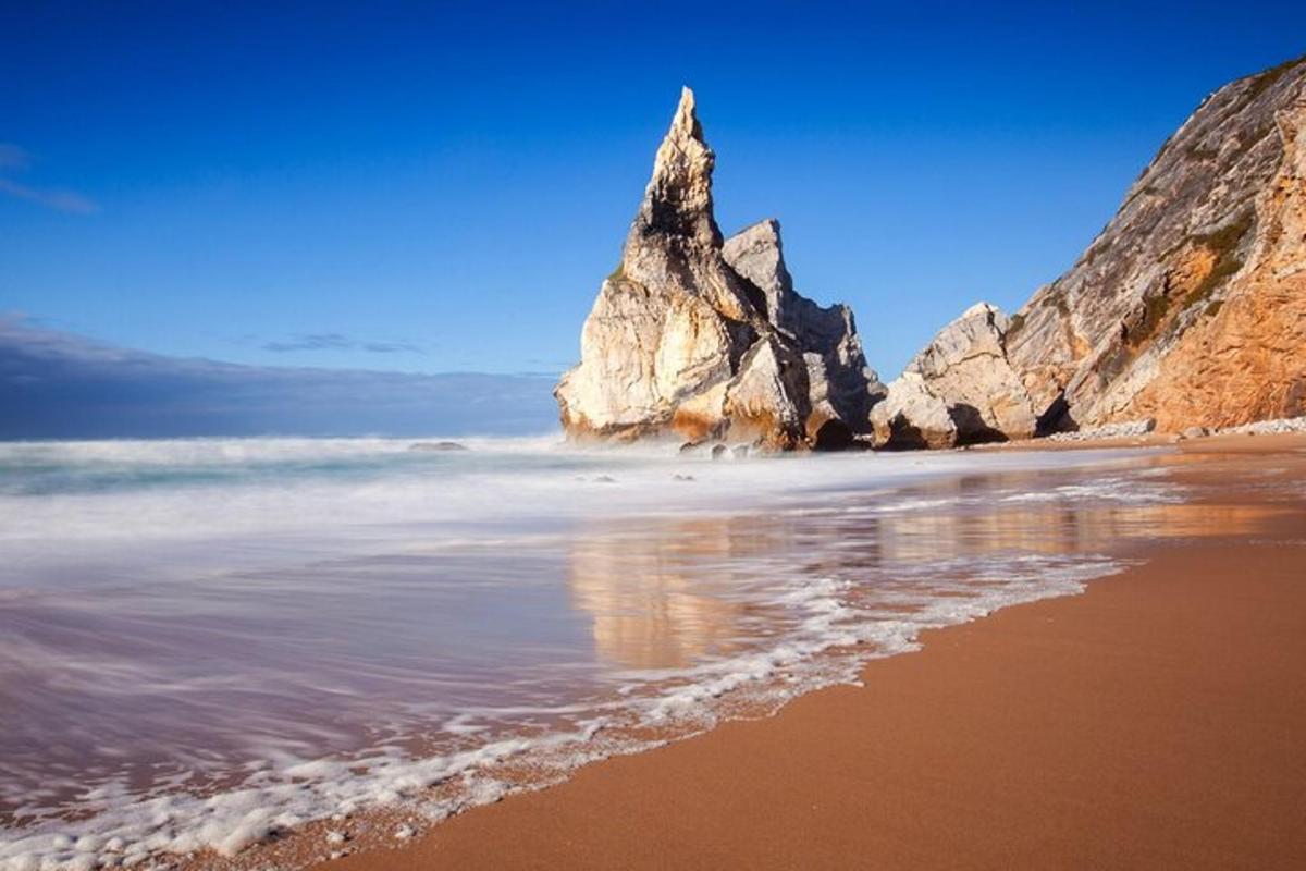 una vista d'una platja amb una formació rocosa