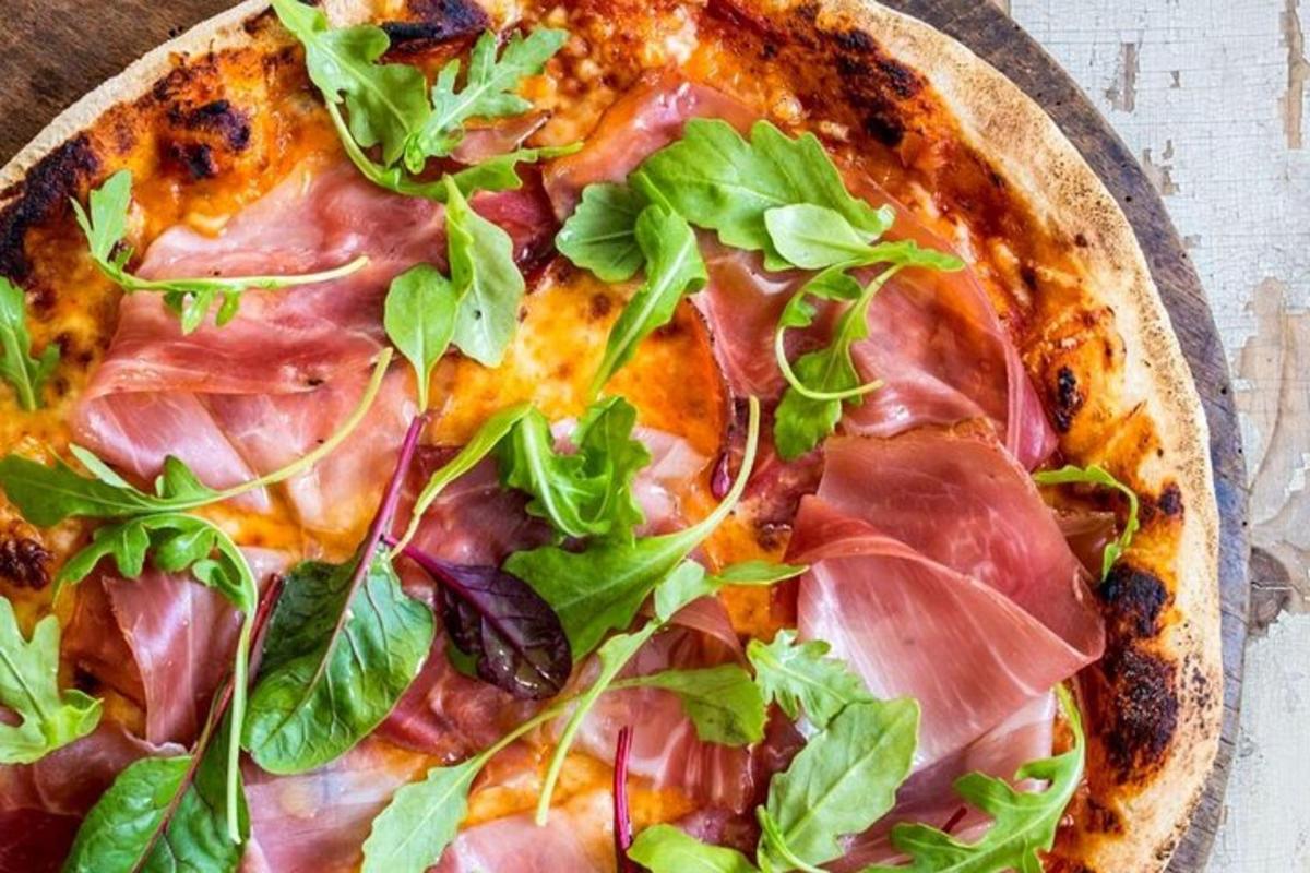 una pizza con verdure sopra su un tavolo