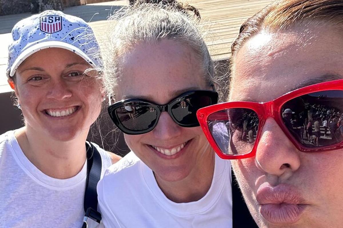 two women and a man wearing red sunglasses