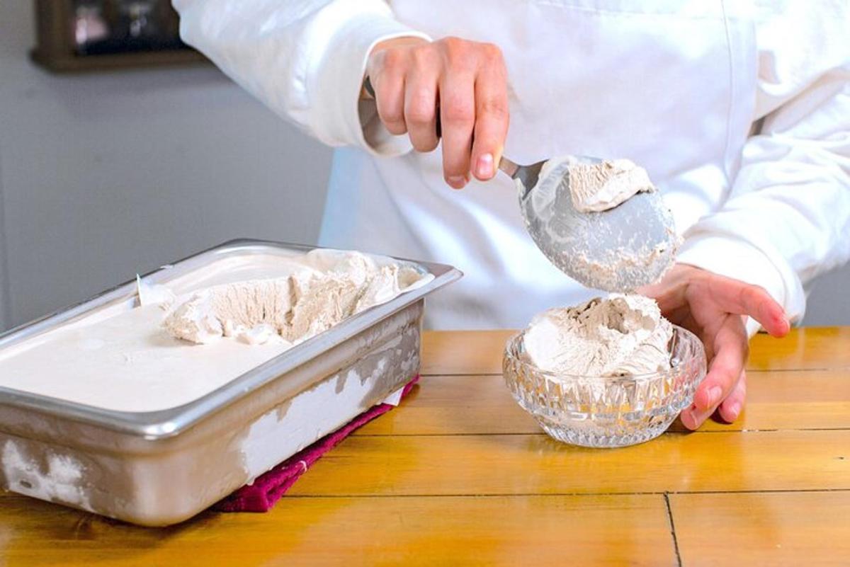 um chef preparando comida em uma panela sobre uma mesa