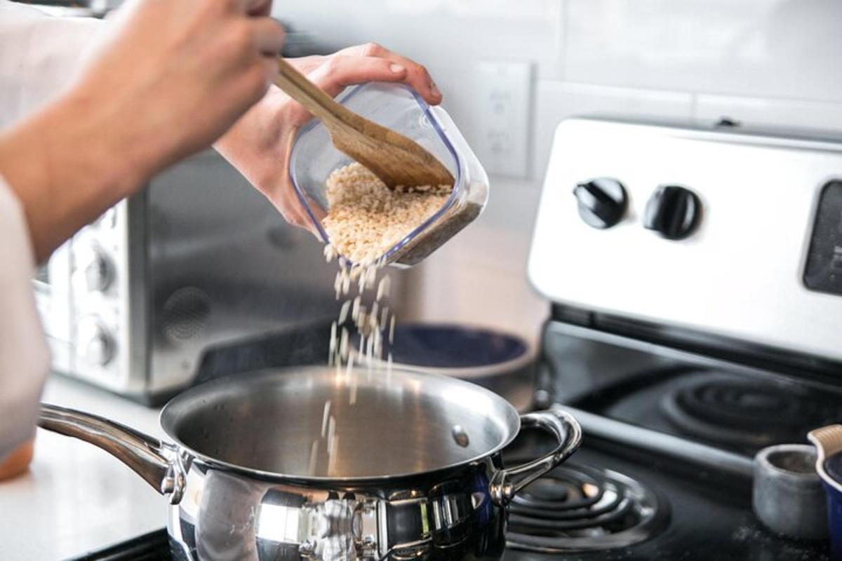 inimene, kes valab pliidil olevasse potti toitu