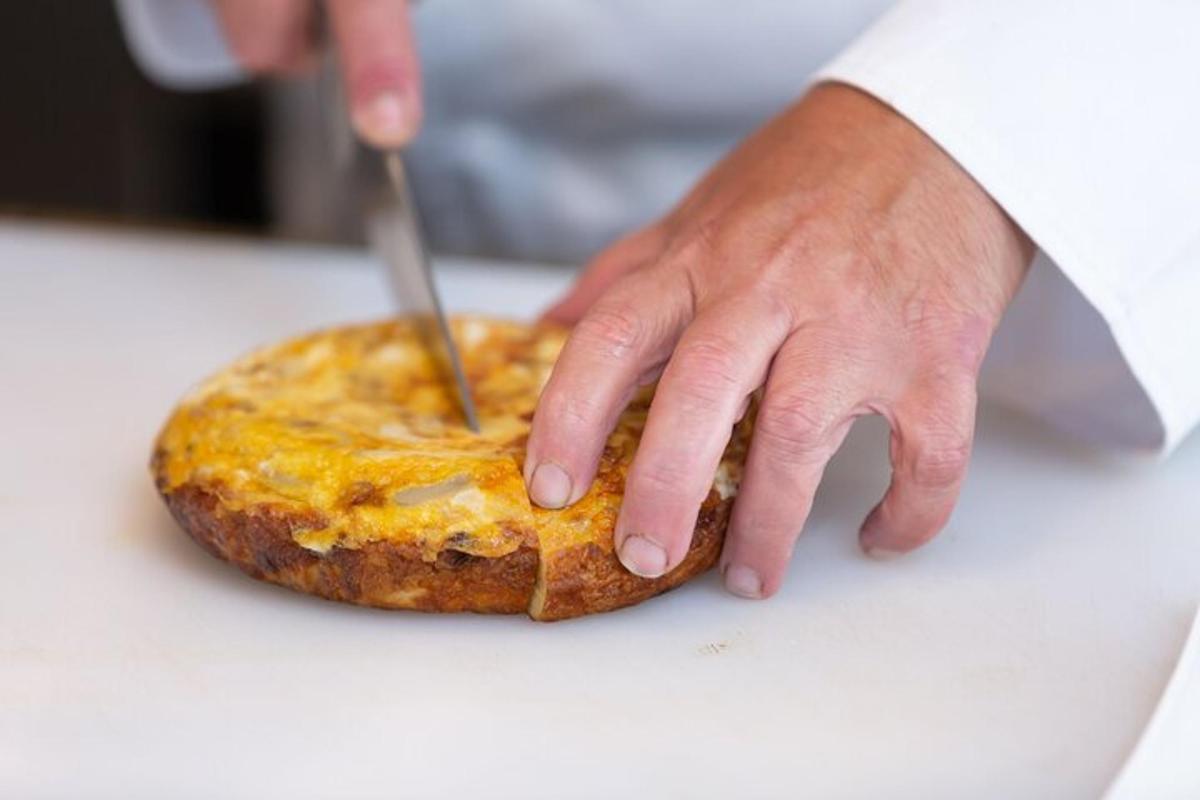 una persona che taglia un pezzo di cibo con un coltello