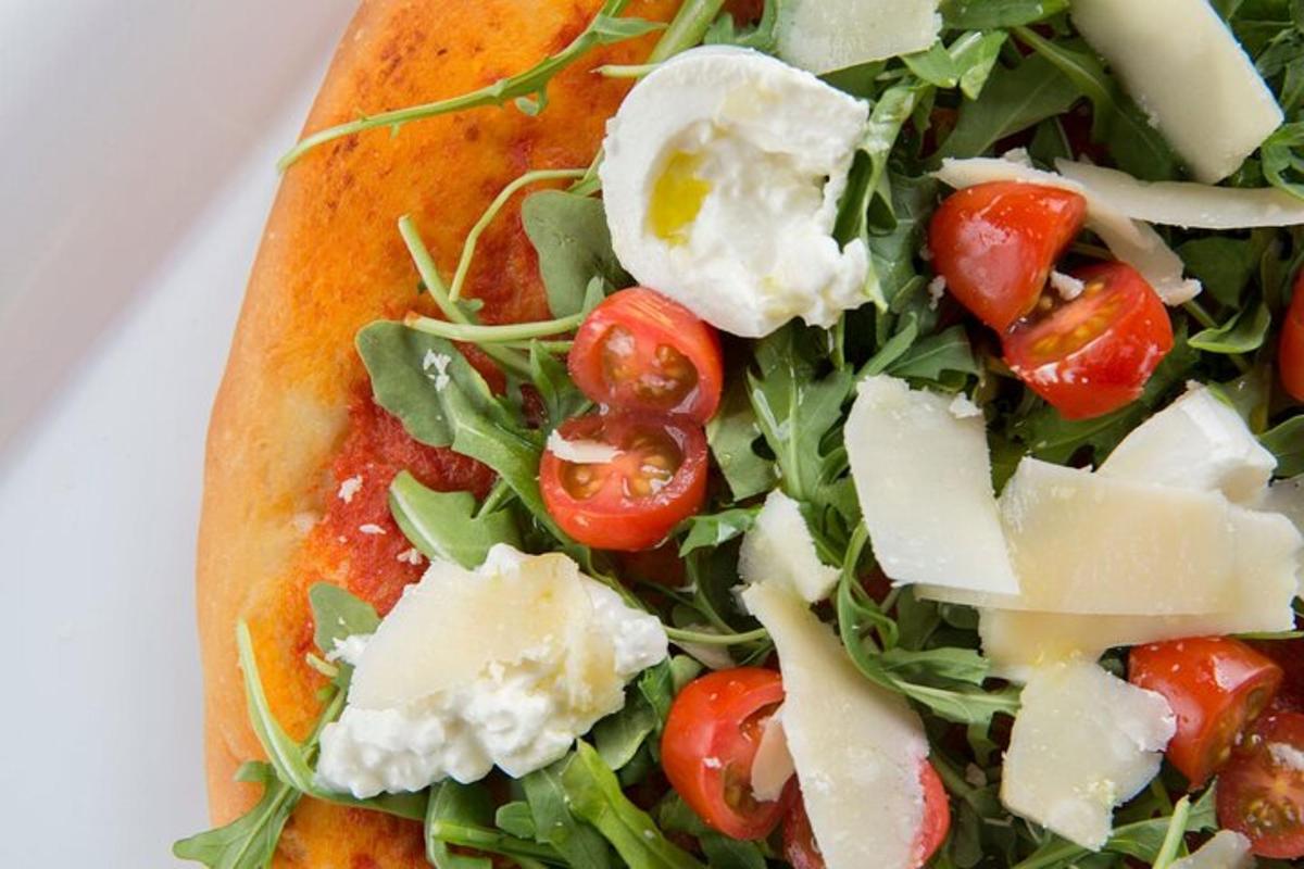 una pizza con pomodori e formaggio su un piatto
