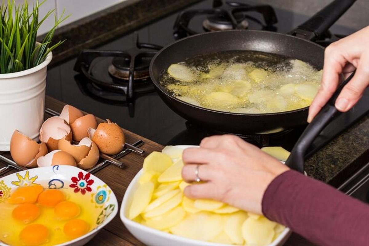 seorang wanita sedang memasak telur dan buah di atas dapur