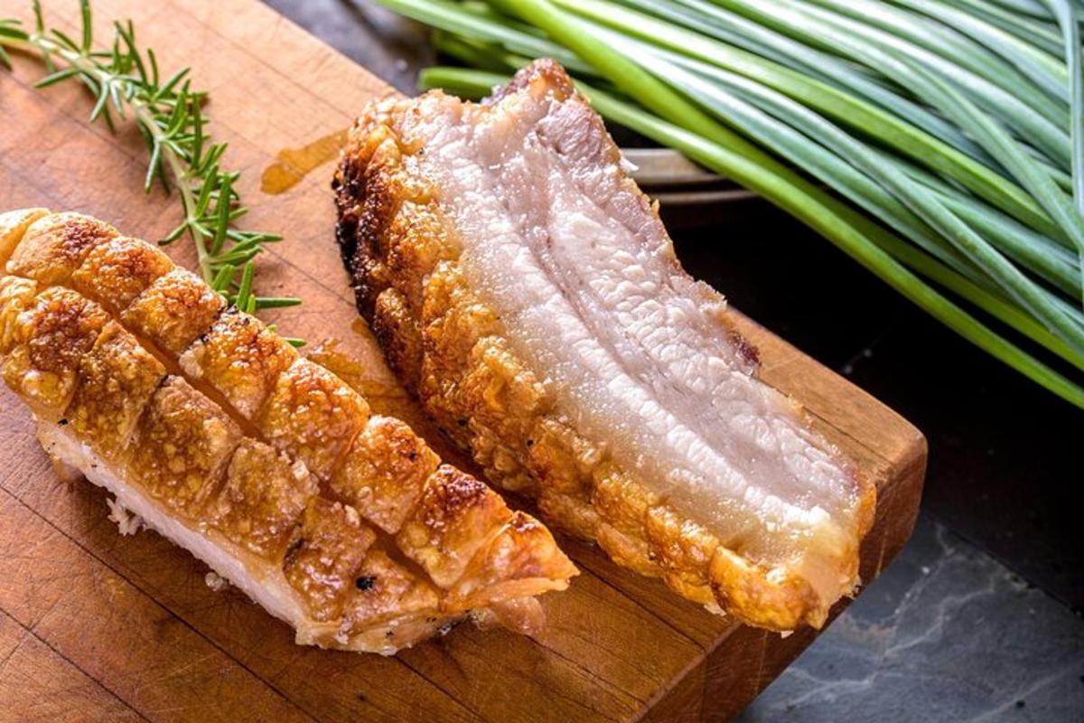 un tagliere di legno con un pezzo di carne e verdure