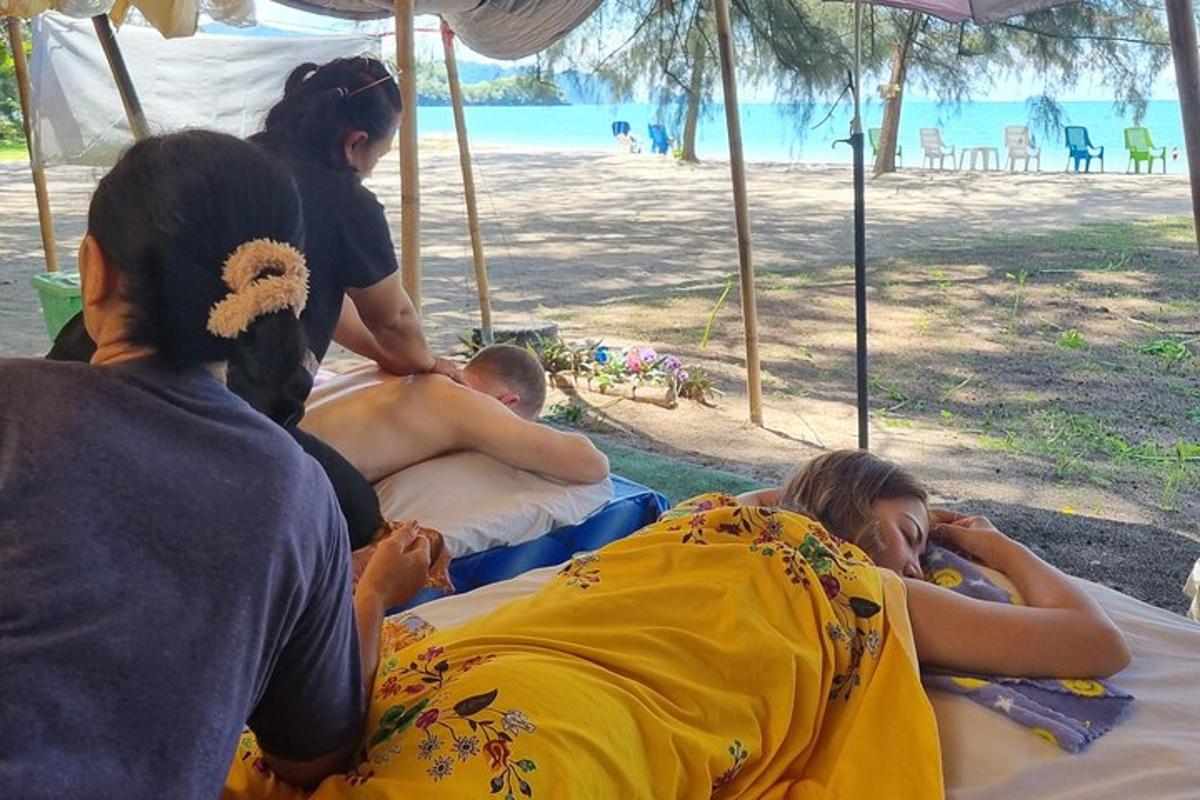 Un grupo de personas tumbadas en camas en la playa.