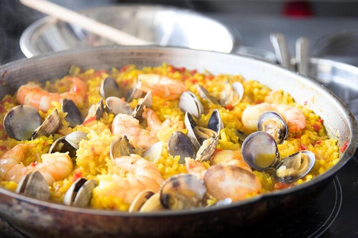 una padella di cibo con gamberi e cozze su riso