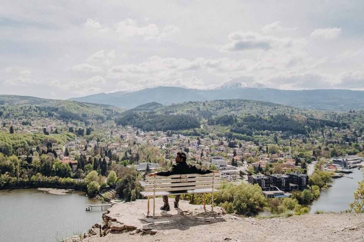 a man sitting on a bench overlooking a city
