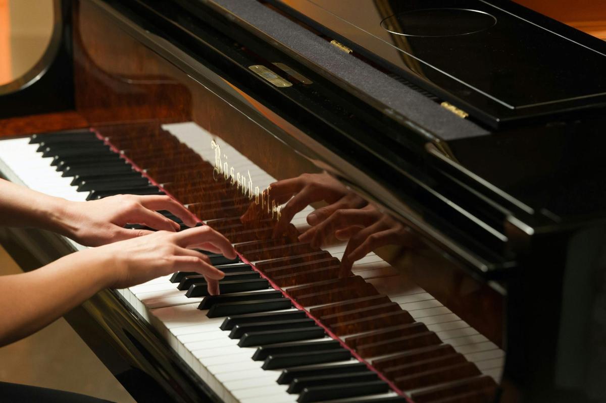 kobieta grająca na pianinie, trzymająca ręce na klawiszach