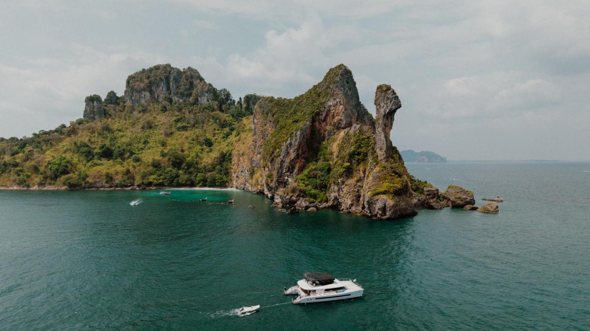 a boat in the water next to a small island