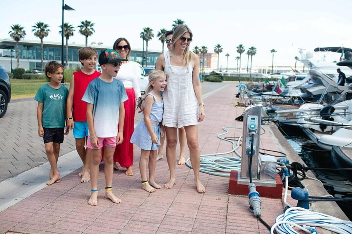 uma família parada ao lado de uma marina com barcos