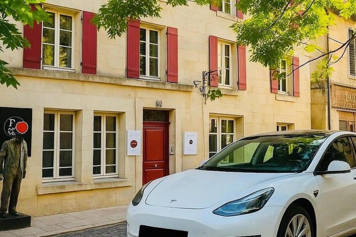 um carro branco estacionado em frente a um prédio